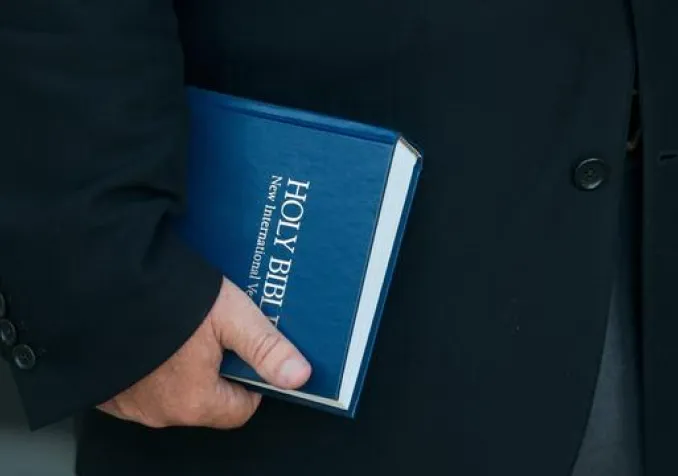 Un pasteur tient une bible. KEYSTONE - STEVE JOHNSON