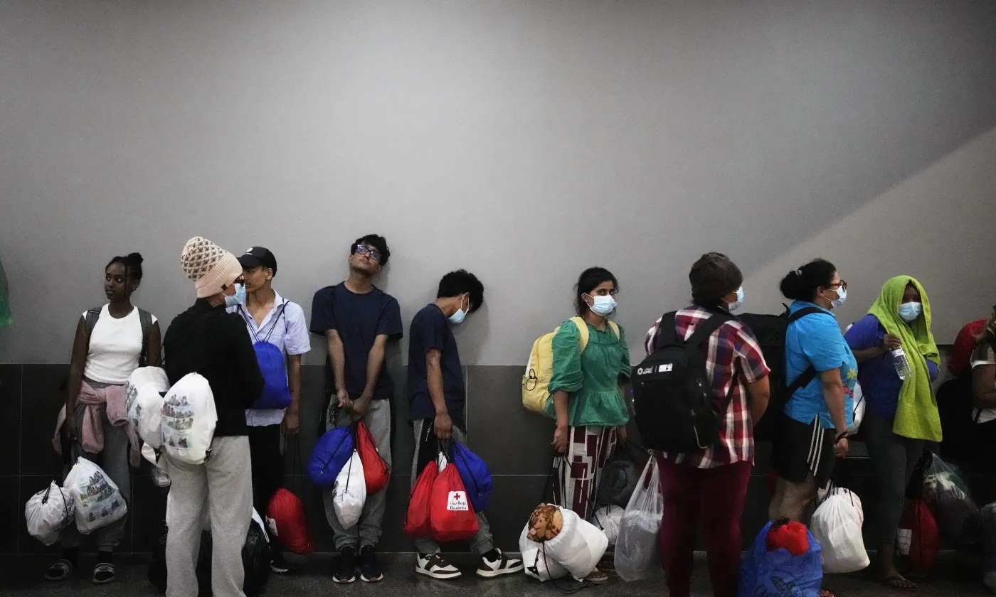 Des migrants, pour la plupart originaires de pays asiatiques, attendent d'être transportés vers des hôtels après leur arrivée à Panama City le samedi 8 mars 2025, après avoir passé des semaines dans un camp d'immigration temporaire panaméen à la suite de leur expulsion des États-Unis et de leur libération à la condition qu'ils quittent le pays dans un délai de 30 jours. Keystone